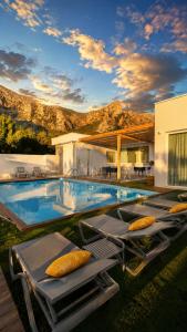 a swimming pool with lounge chairs and a house at Novaeos Sicily in Terrasini