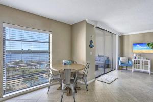 a dining room with a table and chairs and a large window at Marco Magic in Marco Island
