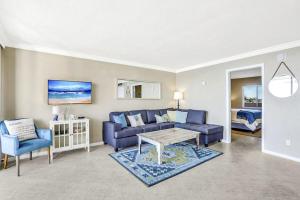 a living room with a blue couch and a table at Marco Magic in Marco Island