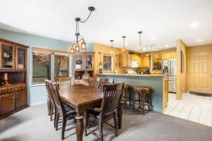 a kitchen and dining room with a wooden table and chairs at Mountainside 612 in Thompsonville