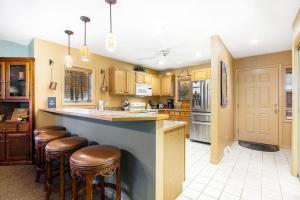 a kitchen with a bar with stools in it at Mountainside 612 in Thompsonville