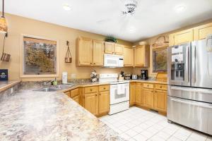 a kitchen with wooden cabinets and white appliances at Mountainside 612 in Thompsonville