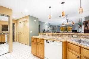a large kitchen with wooden cabinets and a white dishwasher at Mountainside 612 in Thompsonville +25 photos