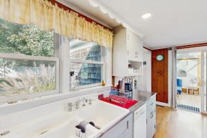 a kitchen with a large white sink and a window at Coastal Hideaway in Eastham +19 photos