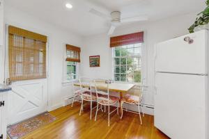 a white kitchen with a table and a refrigerator at Cozy Corner in Edgartown
