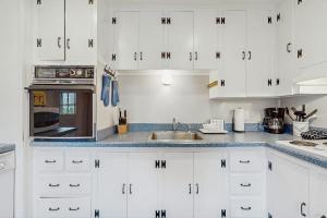 a white kitchen with white cabinets and a sink at Cozy Corner in Edgartown +12 photos
