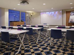 a classroom with tables and chairs and a projection screen at Mercure Marseille Centre Prado Vélodrome in Marseille