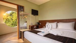 a bedroom with a bed with a bow on it at Inn Room Hotel Bajo in Labuan Bajo