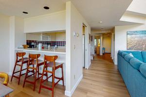 a living room with a blue couch and a kitchen at South Beach 25 in Glen Arbor