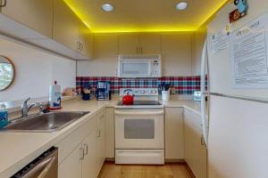 a kitchen with a sink and a white refrigerator at South Beach 25 in Glen Arbor