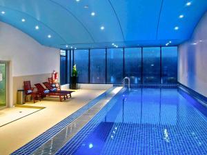 a swimming pool in a hotel with a view of the city at Novotel Sydney Darling Square in Sydney