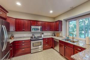 a kitchen with red cabinets and a sink and a refrigerator at Deer Park 9 in Glen Arbor +17 photos
