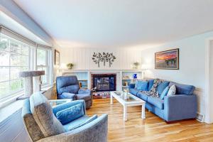 a living room with blue furniture and a fireplace at Yarmouth Bliss in Yarmouth