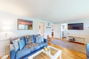 a living room with a blue couch and a table at Yarmouth Bliss in Yarmouth