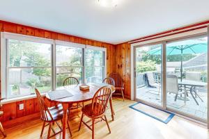 a dining room with a table and chairs and windows at Yarmouth Bliss in Yarmouth
