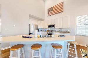 a kitchen with an island with two stools at Bear Trap Dunes---26 Willow Oak Ave in Ocean View +33 photos