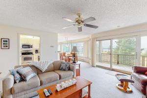 a living room with a couch and a ceiling fan at South Beach 53 in Glen Arbor