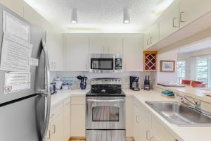 a kitchen with white cabinets and a stainless steel refrigerator at South Beach 53 in Glen Arbor