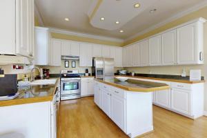 a large kitchen with white cabinets and wooden floors at Beacon Court D in Douglas +21 photos