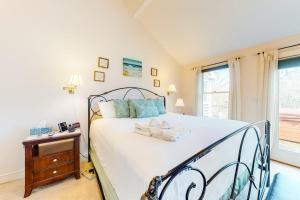 a bedroom with a large white bed with blue pillows at Paradise On Cape Cod in Orleans