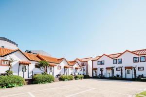 a row of white houses with red roofs at Moon Rabbit Pension in Jeju