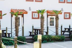 a group of palm trees in front of a building at Moon Rabbit Pension in Jeju