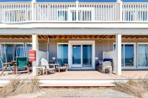 a house with chairs and tables on a patio at Nautical Haven at Seaside in North Truro