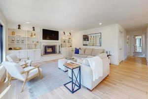 a living room with a white couch and a fireplace at Torch Ridge Residence in Bellaire