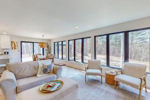 a living room with a couch and chairs and windows at Torch Ridge Residence in Bellaire