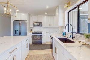 a white kitchen with a sink and a refrigerator at Torch Ridge Residence in Bellaire +7 photos