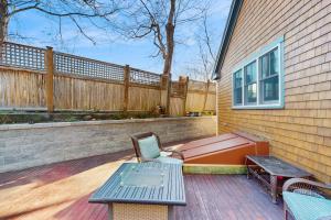 a wooden deck with a bench and a table and a bench at Wraparound Hideaway in Provincetown