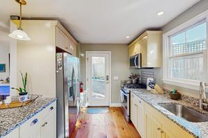 a kitchen with a sink and a refrigerator at Wraparound Hideaway in Provincetown