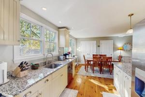 a kitchen with white cabinets and a dining room at Wraparound Hideaway in Provincetown +11 photos