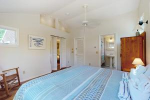 a bedroom with a large blue bed in a room at esCAPE in Eastham