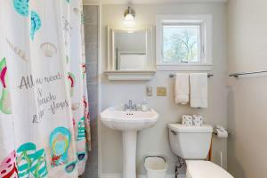 a white bathroom with a sink and a toilet at esCAPE in Eastham