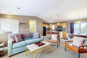 a living room with a blue couch and a kitchen at Northern Light Condominiums: Jack's Perch in Douglas