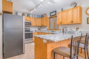 a kitchen with a stainless steel refrigerator and wooden cabinets at McKenzie's Lodge in Thompsonville