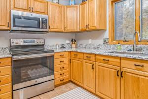 a kitchen with wooden cabinets and stainless steel appliances at McKenzie's Lodge in Thompsonville