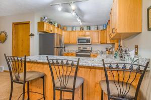 a kitchen with wooden cabinets and a counter with chairs at McKenzie's Lodge in Thompsonville +18 photos