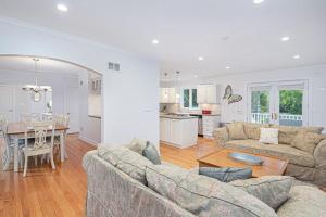 a living room with couches and a table and a kitchen at Butterfly Pool House in Lakeside