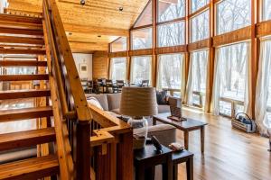 a living room with a staircase in a wooden house at Chalet Du Bois in Harbert