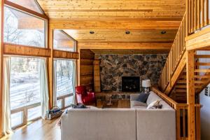 a living room with a couch and a fireplace at Chalet Du Bois in Harbert