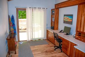 a room with a desk with a computer and a window at Chalet Du Bois in Harbert