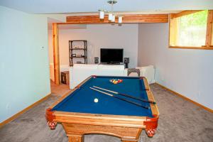 a living room with a pool table with cuesticks at Chalet Du Bois in Harbert