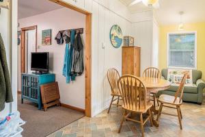 a living room with a table and chairs and a television at Goshorn Lake's Endless Summer in Saugatuck