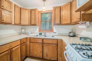 a kitchen with wooden cabinets and a sink and a stove at Goshorn Lake's Endless Summer in Saugatuck