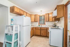 a kitchen with a white refrigerator and wooden cabinets at Goshorn Lake's Endless Summer in Saugatuck