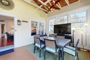 a dining room with a table and chairs and a television at Rise n Shine in Saugatuck