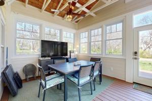 a dining room with a table and chairs and a flat screen tv at Rise n Shine in Saugatuck