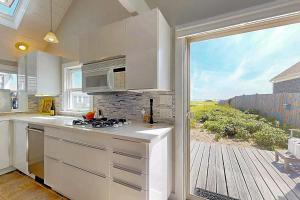 a kitchen with a stove top oven next to a window at Anchorage Escape in Truro +17 photos